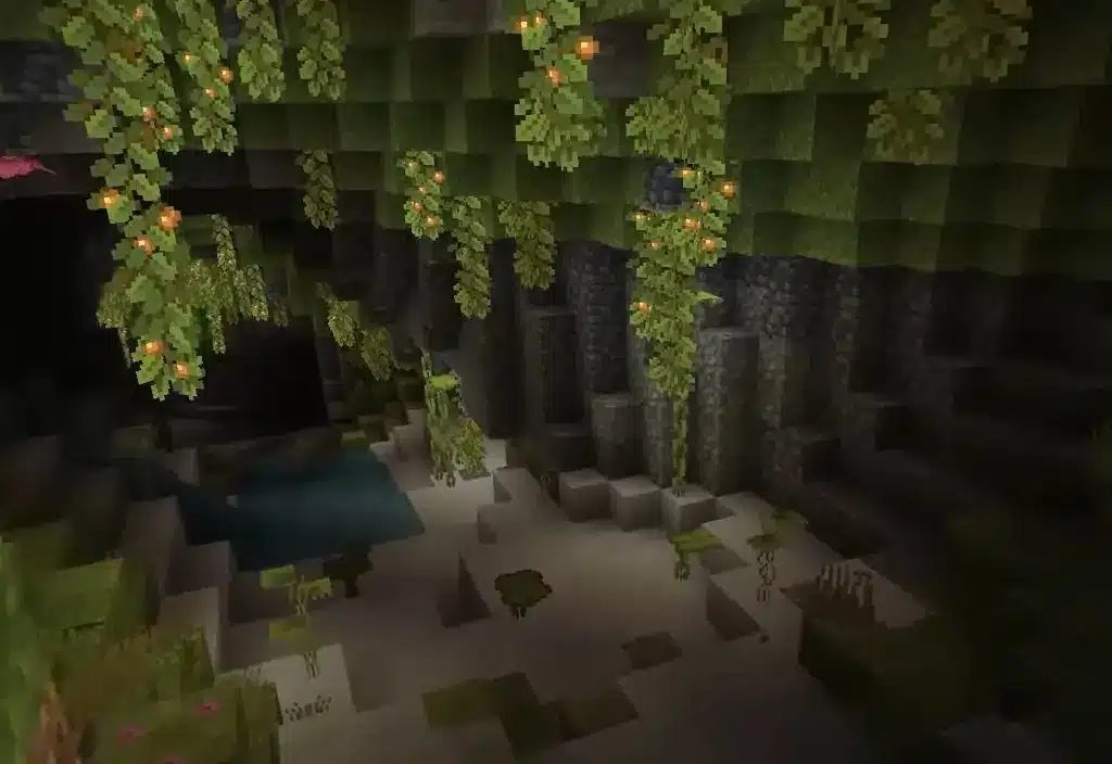 En visning af et Lush Caves-biom i Minecraft med hængende lysbær og grønne planter.