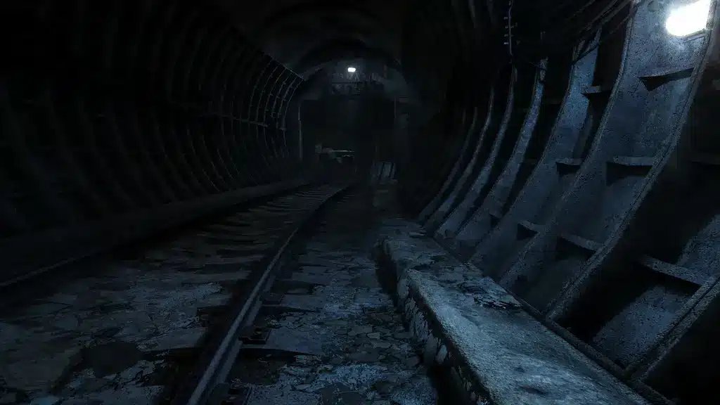 En mørk, atmosfærisk udsigt over en forladt metrotunnel med rustne metalkonstruktioner og dæmpet belysning.