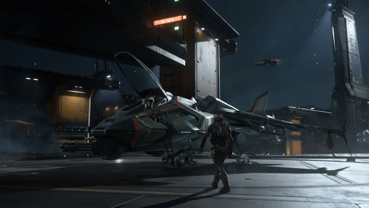 En pilot står ved siden af en strømlinet, grå stjernejager på et futuristisk hangardæk på en rumstation i Squadron 42.